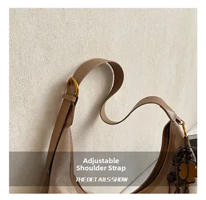 Détail de la bandoulière réglable en cuir avec boucle en métal et texture suédée