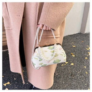 Detail der Vintage-Tasche mit Lotus-Stickerei, Metallrahmen und Perlenkette