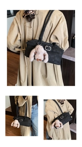 Gros plan du sac Boston noir rétro avec un pendentif lapin en peluche beige