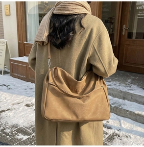 Détail de la broderie de tournesol et texture daim mat sur le sac fourre-tout chameau
