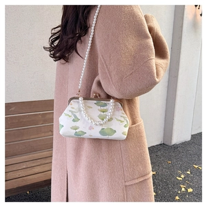 Detail of vintage lotus embroidery bag with pearl chain and elegant metal frame clasp