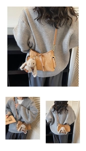 Detail of caramel suede crossbody bag with cute plush long-eared rabbit charm accessory