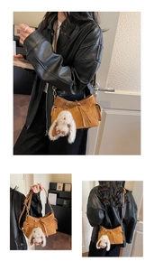 Detail of retro brown suede handbag with side pockets and plush rabbit charm