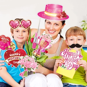 Family holding Mother's Day photo booth props including heart glasses and party signs