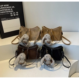 Detailed display of four retro crossbody bags in suede brown, khaki, and black with cute bunny charms