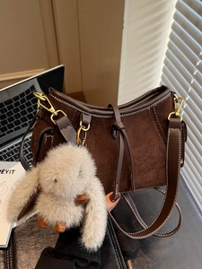 Retro dark brown suede shoulder bag with contrast stitching and plush rabbit charm