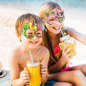 Bambini che indossano occhiali da festa Aloha con fenicottero e ananas sulla spiaggia estiva