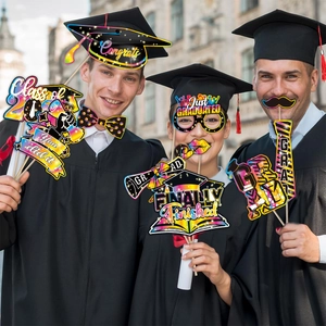 Close-up of 2026 graduation photo booth props with colorful glitter signs and masks