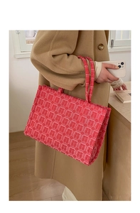 Close-up of the red jacquard fabric with traditional Double Happiness patterns on a tote bag