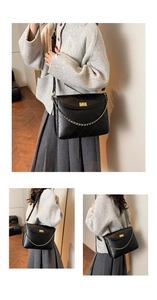 Detail of black quilted leather tote bag with gold chain and metal twist lock