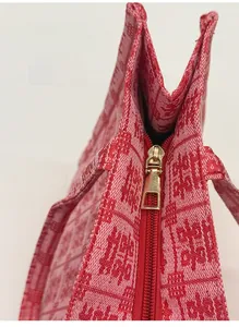 Detail of smooth metal zipper and festive red woven fabric with traditional patterns