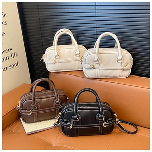 Detailed view of four colorful PU leather Boston bags with contrast stitching and dual handles