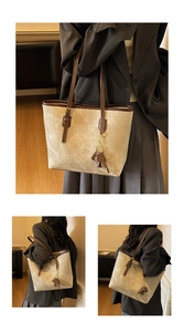 Detail view of large tote bag with vintage texture and brown elephant charm decoration