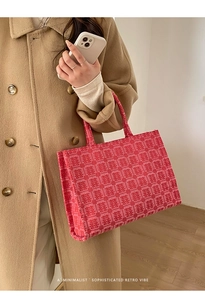Macro detail of red bridal tote bag featuring traditional Chinese wedding jacquard patterns