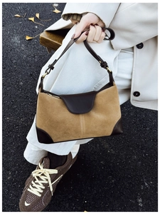 Detail of khaki suede and brown leather patchwork shoulder bag with ginkgo leaves