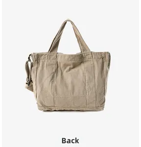 Back view of a large khaki canvas tote bag featuring reinforced straps and adjustable shoulder belt