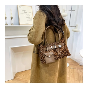 Detail of leopard print tote bag with brown leather handles and mini pouch accessory