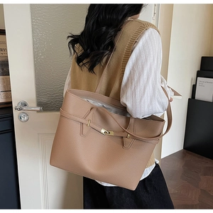 Close-up of khaki lychee grain leather tote bag with elegant gold buckle and strap