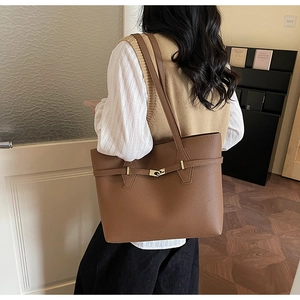 Close-up of caramel brown tote bag featuring premium lychee texture and gold metal buckle