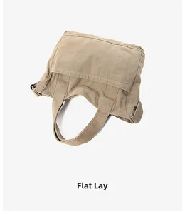 Flat lay view of khaki canvas tote bag showing durable texture and large front pocket