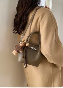 Litchi pattern leather bucket bag with lock clasp and cute plush bear accessory