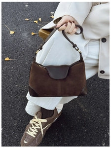 Detail of dark brown suede patchwork shoulder bag with vintage gold metal buckle
