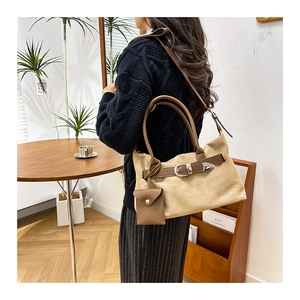 Detail of khaki faux suede tote bag with leather strap buckle and mini coin purse charm