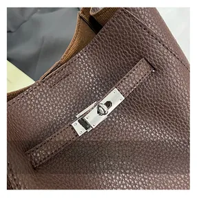 Detailed macro view of dark brown lychee leather and silver metal twist lock closure