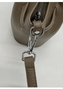 Detail of silver metal buckle and D-ring on dark brown litchi pattern leather bucket bag