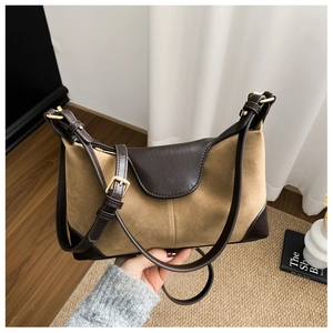 Detail of retro patchwork shoulder bag featuring suede texture and gold buckle