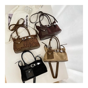 Macro detail of faux suede tote bags in leopard, brown, and black with metal buckles
