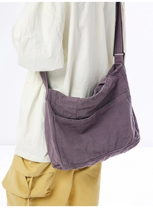 Side view of dark purple canvas crossbody bag showing large capacity and exterior pockets