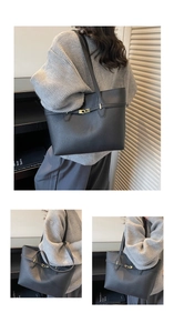 Close-up of black lychee-grain leather tote bag with elegant gold metal twist lock detail