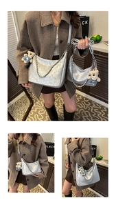 Détail du sac cabas argenté texturé avec chaîne en métal et accessoire charme ours en peluche