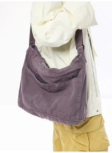 Detailed view of purple washed canvas shoulder bag showing multi-pocket design on model