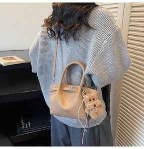 Détail du sac seau en cuir grainé kaki avec boucle en métal et breloque chien en peluche
