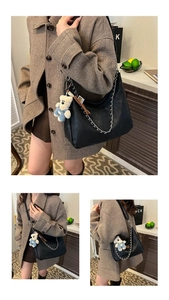 Détail d'un sac cabas en cuir noir avec chaîne argentée et breloque ours en peluche mignonne