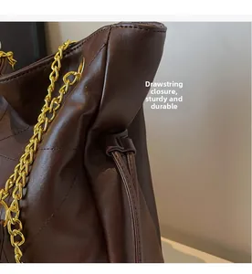 Detail of dark brown quilted leather bag featuring a gold chain strap and drawstring closure