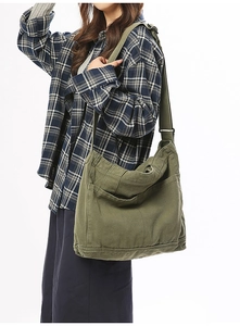 Army green large canvas crossbody bag with wide adjustable strap and side pocket detail