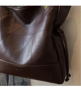 Detail of dark brown quilted tote bag showing leather texture and drawstrings