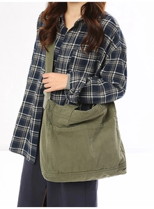Close-up of army green canvas messenger bag with functional pockets and wide strap