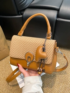 Borsa retrò a contrasto con serratura tonda in metallo e ciondolo a cuore con nappa