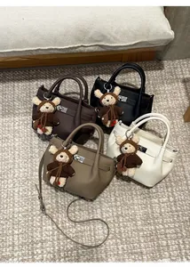 Detailed top view of four bucket bags in various colors with cute teddy bear charms