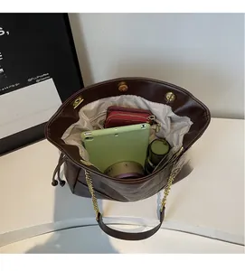 Interior view of deep brown leather bucket bag showing storage space for tablet and wallet