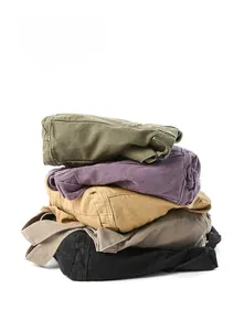 Close-up of stacked casual canvas pants in various colors including olive and khaki