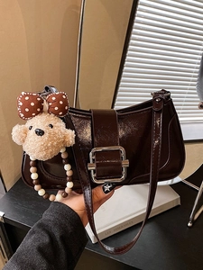 Dark brown patent leather baguette bag with silver buckle and cute teddy bear charm