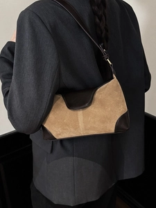 Retro khaki suede and brown leather shoulder bag shown on a model with grey blazer