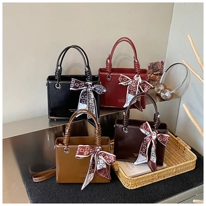 Detailed display of four vintage bucket bags in various colors with decorative scarves