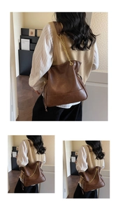 Detailed close-up of brown vintage leather shoulder bag with gold chain strap and stitching