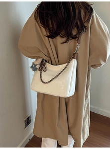 Détail du sac demi-lune blanc crème avec bandoulière en cuir et chaîne argentée
